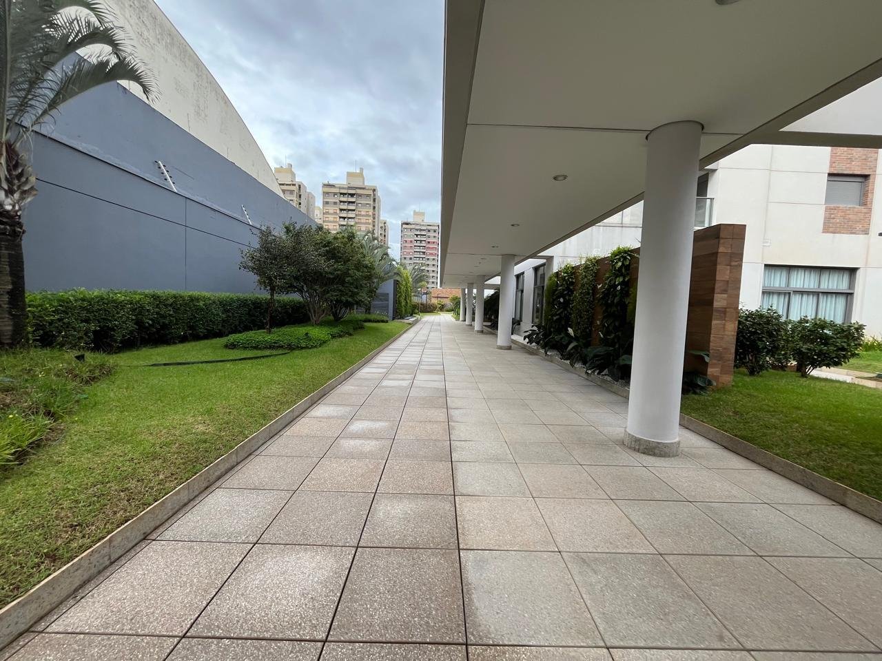 Acesso secundário do Sartoria Taquaral com porta de vidro e vaso de planta