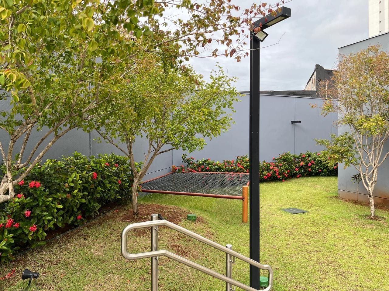 Jardim lateral com palmeiras e gramado no Sartoria Taquaral