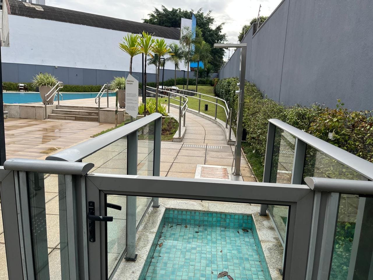Entrada da área da piscina Sartoria Taquaral com lava-pés e jardim