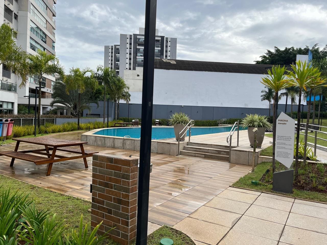 Área da piscina Sartoria Taquaral com deck e mesa de piquenique