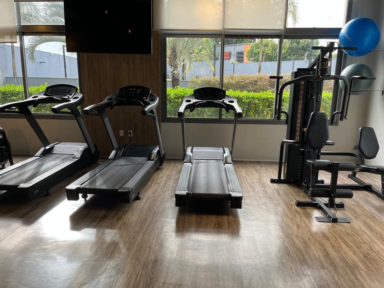 Área cardio da academia Sartoria Taquaral com esteiras e vista para jardim