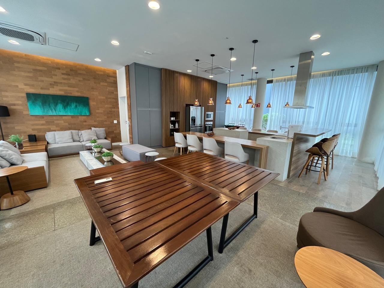 Espaço gourmet do Sartoria Taquaral com ilha, bancada de madeira e pendentes de cobre